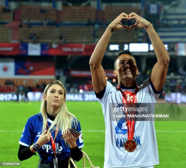 Chennayin FC player Mailson Alves gestures towards fans while his girlfriend looks on after the team's 3-2 victory against Bengaluru FC in the final...