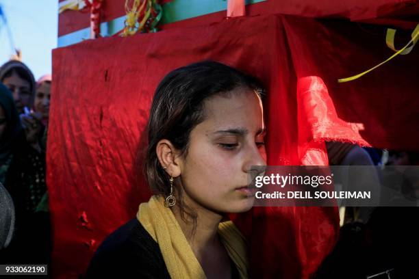 Woman mourns while standing next to a coffin during the funeral of People's Protection Units fighters in the northeastern Syrian city of Qamishli on...