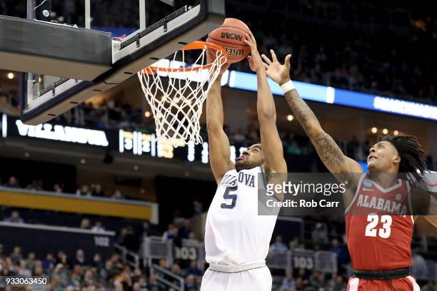 Phil Booth of the Villanova Wildcats dunks the ball against John Petty of the Alabama Crimson Tide during the second half in the second round of the...