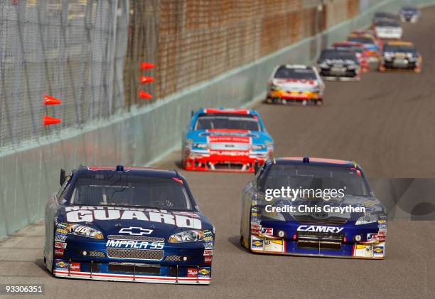 Dale Earnhardt Jr., driver of the National Guard/AMP Energy Chevrolet, races against David Reutimann, driver of the Aaron's Dream Machine Toyota,...