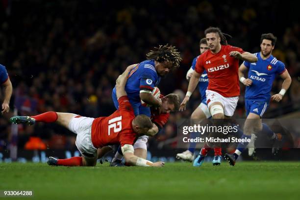 Dan Biggar of Wales and Hadleigh Parkes of Wales tackles Mathieu Bastareaud of France during the NatWest Six Nations match between Wales and France...