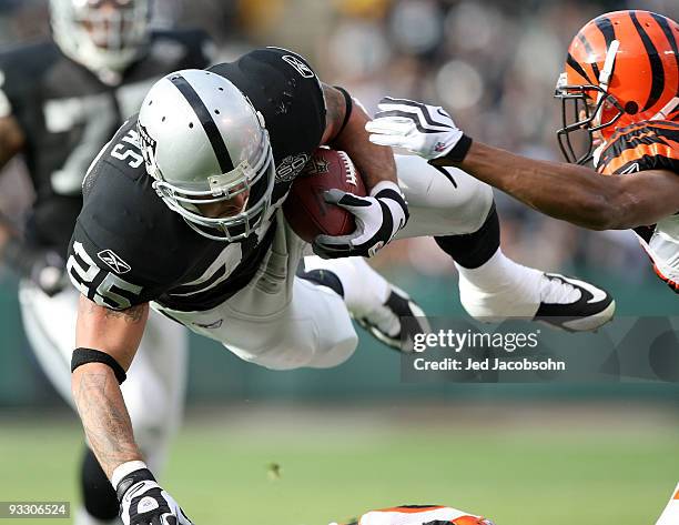 Justin Fargas of the Oakland Raiders runs against Leon Hall of the Cincinnati Bengals during an NFL game at Oakland-Alameda County Coliseum on...