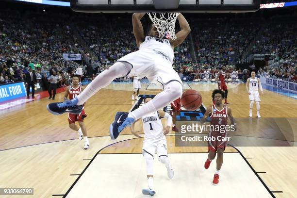 Phil Booth of the Villanova Wildcats dunks the ball against John Petty of the Alabama Crimson Tide during the second half in the second round of the...