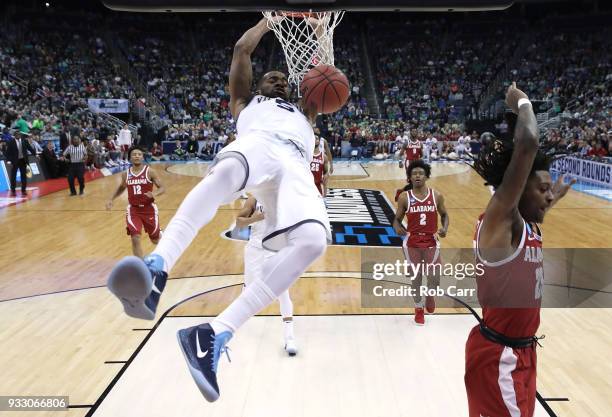 Phil Booth of the Villanova Wildcats dunks the ball against John Petty of the Alabama Crimson Tide during the second half in the second round of the...