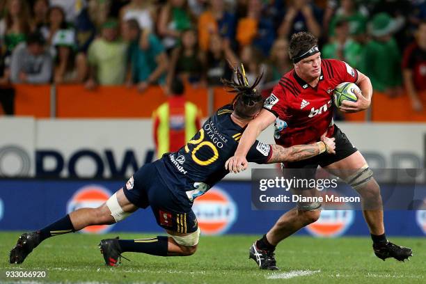 Scott Barrett of the Crusaders is tackled by Elliot Dixon of the Highlanders during the round five Super Rugby match between the Highlanders and the...