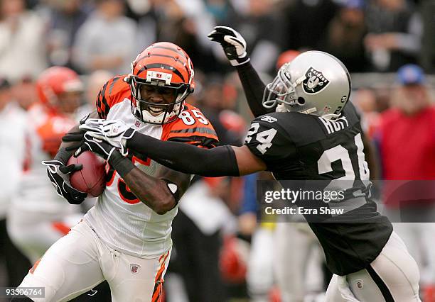 Chad Ochocinco of the Cincinnati Bengals is tackled by Michael Huff of the Oakland Raiders at Oakland-Alameda County Coliseum on November 22, 2009 in...