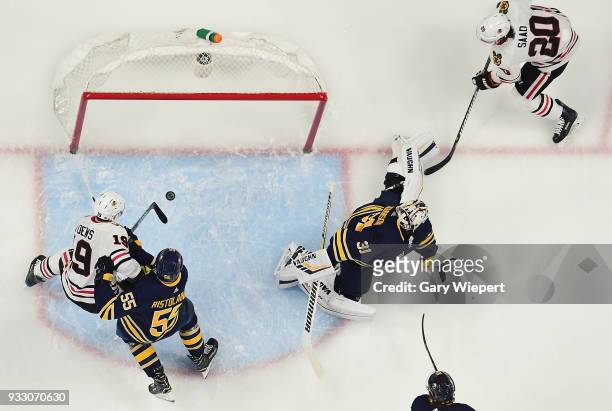 Chad Johnson and Rasmus Ristolainen of the Buffalo Sabres defend against Brandon Saad and Jonathan Toews of the Chicago Blackhawks during an NHL game...