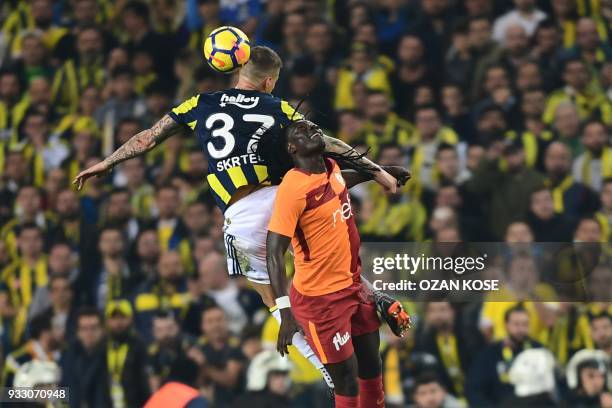 Fenerbahce's defender Martin Skrtel heads the ball next to Galatasaray's Bafetimbi Gomis during Turkish Spor Toto Super league fotball match between...