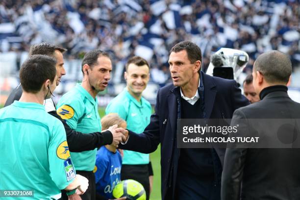 Bordeaux's Uruguayan head coach Gustavo Poyet shakes the referees' hands prior to the French L1 football match between Bordeaux and Rennes on March...