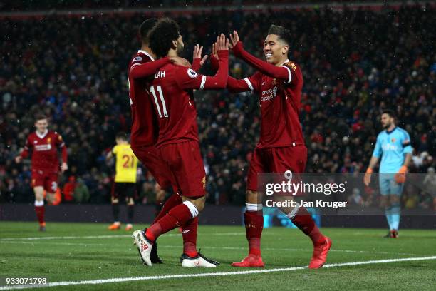 Roberto Firmino of Liverpool celebrates scoring his side's third goal with Mohamed Salah and Joe Gomez during the Premier League match between...