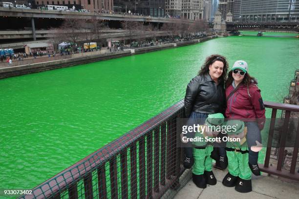 Visitors pose for pictures along the Chicago River shortly after it was dyed green in celebration of St. Patrick's Day on March 17, 2018 in Chicago,...