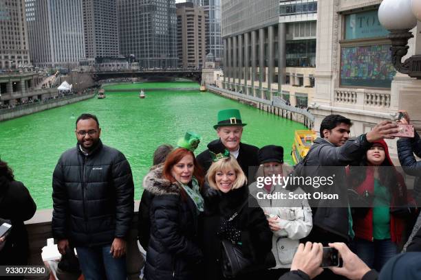 Visitors pose for pictures along the Chicago River shortly after it was dyed green in celebration of St. Patrick's Day on March 17, 2018 in Chicago,...