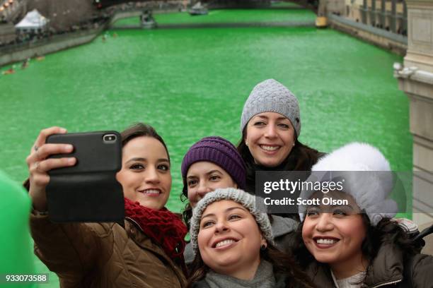 Visitors pose for pictures along the Chicago River shortly after it was dyed green in celebration of St. Patrick's Day on March 17, 2018 in Chicago,...