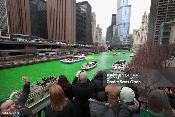 Visitors take pictures of the Chicago River shortly after it was dyed green in celebration of St. Patrick's Day on March 17, 2018 in Chicago,...