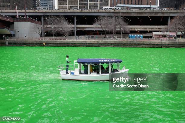 Boat navigates the Chicago River shortly after it was dyed green in celebration of St. Patrick's Day on March 17, 2018 in Chicago, Illinois. Dyeing...