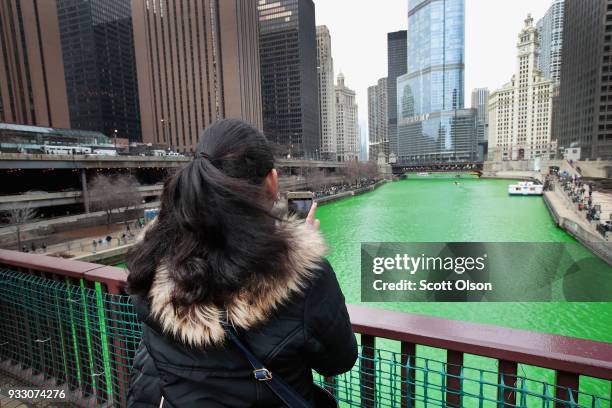 Visitors take pictures of the Chicago River shortly after it was dyed green in celebration of St. Patrick's Day on March 17, 2018 in Chicago,...