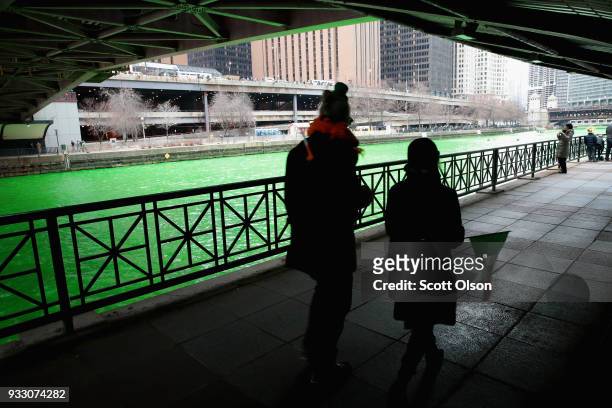 Visitors walk along the Chicago River shortly after it was dyed green in celebration of St. Patrick's Day on March 17, 2018 in Chicago, Illinois....