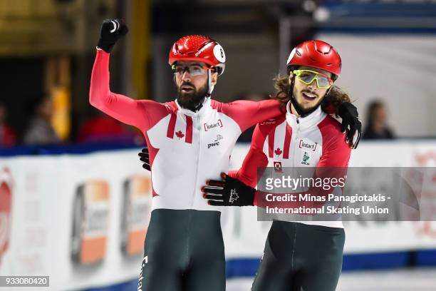 Charles Hamelin of Canada receives a hug by teammate Samuel Girard of Canada after finishing first in the men's 1500 meter finals during the World...