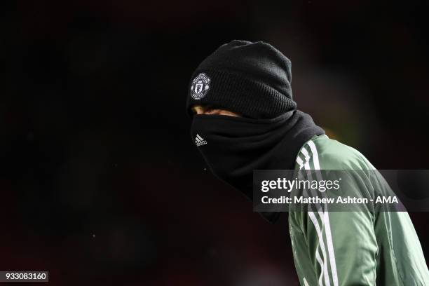 David de Gea of Manchester United wears a hat and snood in the cold weather whilst warming up during the FA Cup Quarter Final match between...