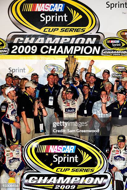 Jimmie Johnson, driver of the Lowe's Chevrolet, celebrates with the trophy after winning the NASCAR Sprint Cup Series Championship after finishing in...