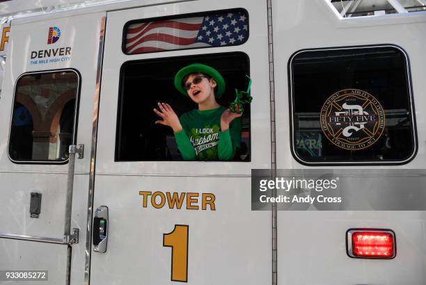 Jay Stone, getting a ride in his dad's fire truck Denver Fire Tower, gestures to the crowd that he ran out of candy to throw to them during the...
