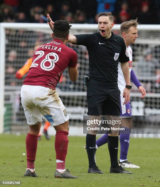 Referee Ben Toner waves away the protest of Hildeberto Pereira of Northampton Town during the Sky Bet League One match between Northampton Town and...