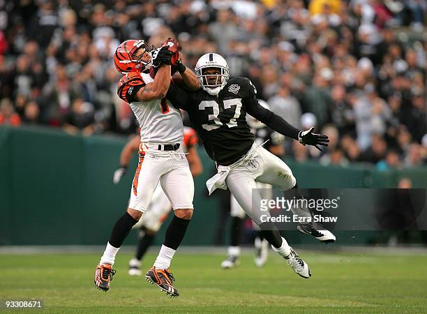 Laveranues Coles of the Cincinnati Bengals comes down with the ball while defended by Chris Johnson of the Oakland Raiders at Oakland-Alameda County...