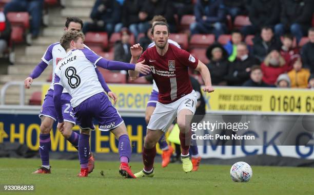 John-Joe O'Toole of Northampton Town moves with the ball past Matt Palmer of Rotherham United during the Sky Bet League One match between Northampton...