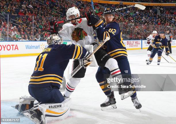 Tomas Jurco of the Chicago Blackhawks is defended by Nathan Beaulieu and Chad Johnson of the Buffalo Sabres during an NHL game on March 17, 2018 at...