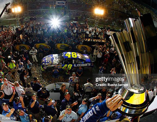 Jimmie Johnson , driver of the Lowe's Chevrolet, hoists the trophy after winning the NASCAR Sprint Cup Series Championship after finishing in fifth...