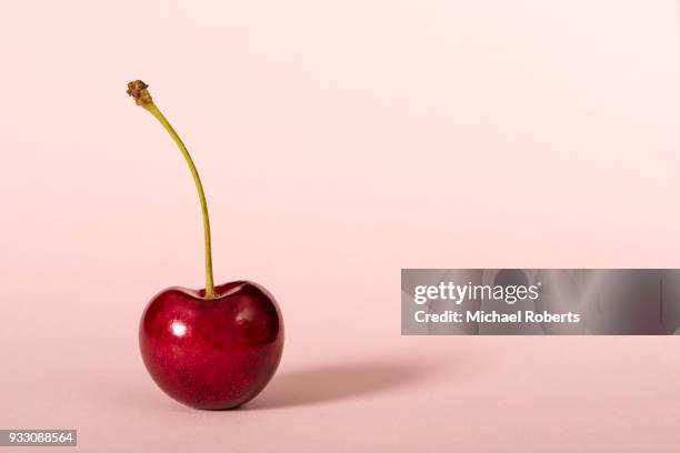 cherry on pink plain background - cherry stock pictures, royalty-free photos & images