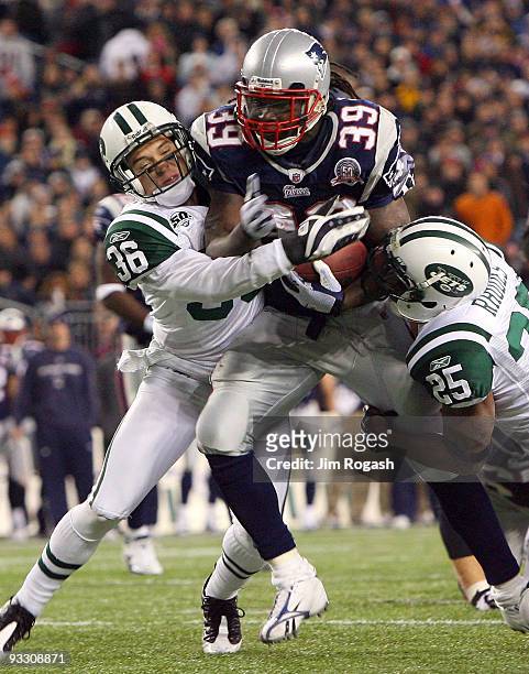 Laurence Maroney of the New England Patriots gains yardage against the defense of Jim Leonhard and Kerry Rhodes in the fourth quarter during a game...
