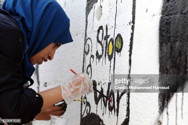 Yemeni artist draws graffiti during an Open Day of graffiti campaign call for peace on March 15, 2018 in Sana'a, Yemen.