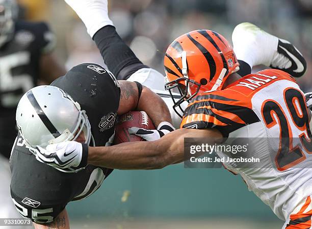 Justin Fargas of the Oakland Raiders runs against Leon Hall of the Cincinnati Bengals during an NFL game at Oakland-Alameda County Coliseum on...