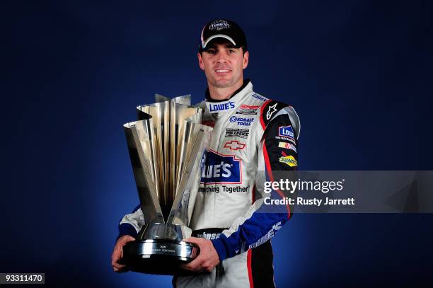 Jimmie Johnson, driver of the Lowe's Chevrolet, poses the trophy after winning the NASCAR Sprint Cup Series Championship at Homestead-Miami Speedway...