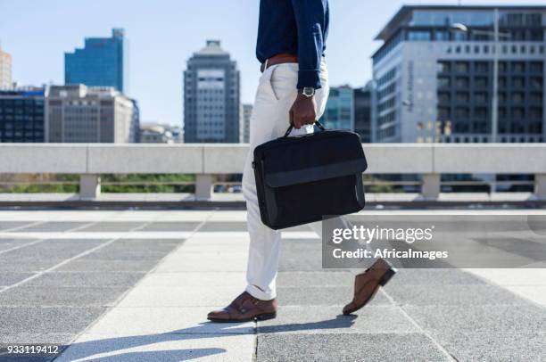 businessman carrying his laptop bag walking through the city. - laptop bag stock pictures, royalty-free photos & images