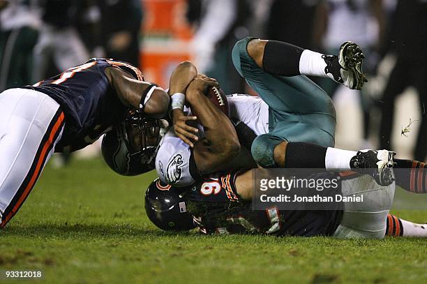 Donovan McNabb of the Philadelphia Eagles is sacked by Hunter Hillenmeyer and Mark Anderson of the Chicago Bears at Soldier Field on November 22,...