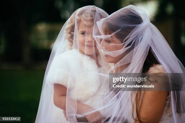 young beautiful bride embracing little flower girl at wedding - daughter wedding stock pictures, royalty-free photos & images