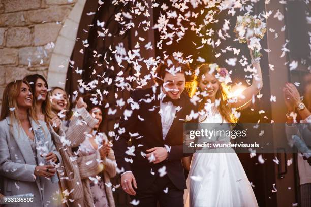 feliz novia y el novio saliendo de la iglesia y celebración - ceremonia matrimonial fotografías e imágenes de stock