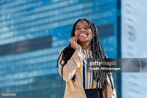 portret van een goed uitziende zakenvrouw praten op haar mobiele telefoon in de stad. - african cityscape stockfoto's en -beelden