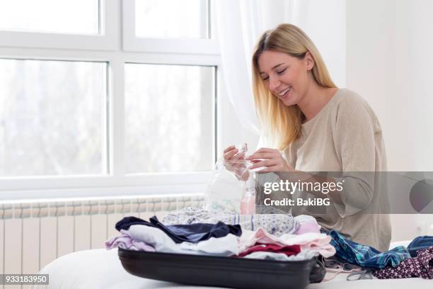 giovane donna che impacchetta una valigia - toiletries foto e immagini stock