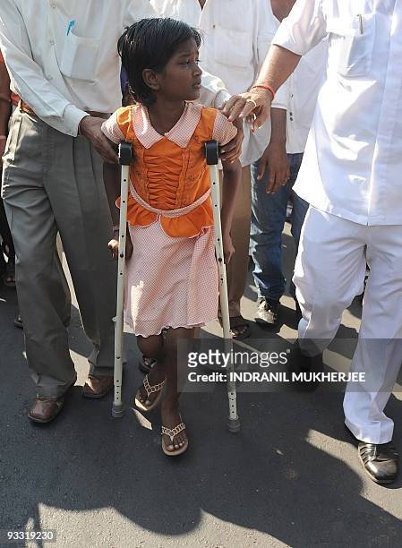 Ten year-old Devika Rotawan, a survivor of the November 2008 militant attacks, walks with the help of crutches after a protest against the lone...