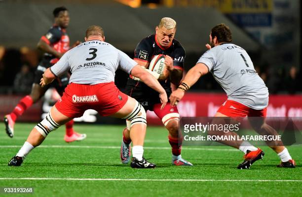 Oyonnax' New Zealand flanker Hika Elliot is challenged by Toulon's South African prop Marcel Van Der Merwe and Toulon's French prop Florian Fresia...