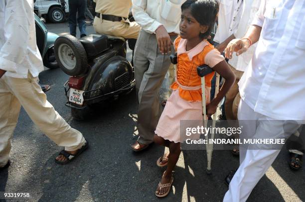 Ten year-old Devika Rotawan, a survivor of the November 2008 militant attacks, walks with the help of crutches after a protest against the lone...