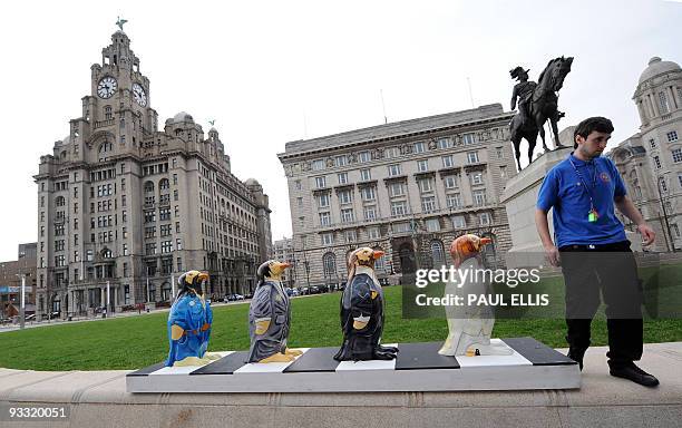 Fibreglass penguin charicatures of the Beatles in their famous Abbey Road crosswalk pose stand on the pier head in Liverpool, north-west England on...