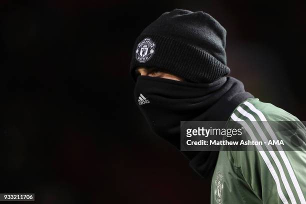 David de Gea of Manchester United wears a hat and snood in the cold weather whilst warming up during the FA Cup Quarter Final match between...