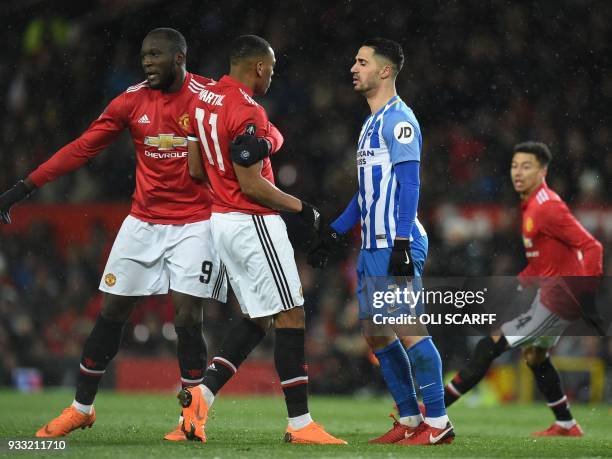 Manchester United's Belgian striker Romelu Lukaku pulls Manchester United's French striker Anthony Martial from a dispute with Brighton's Israeli...