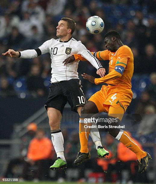 Lukas Podolski of Germany and Kolo Toure of Ivory Coast jumps for a header during the International Friendly match between Germany and Ivory Coast at...