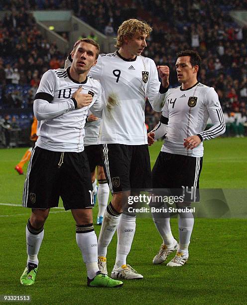 Lukas Podolski of Germany and his team mates Piotr Trochowski and Stefan Kiessling celebrate the first goal during the International Friendly match...