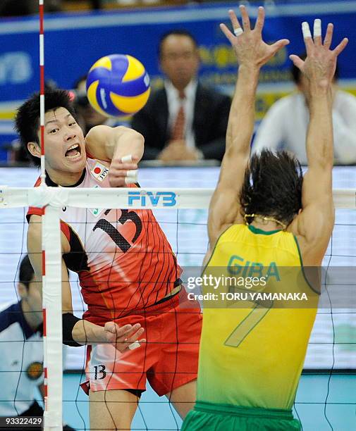 Kunihiro Shimizu of Japan spikes the ball through Gilberto Godoy Filho of Brazil during their match at the men's Grand Championship Cup volleyball...